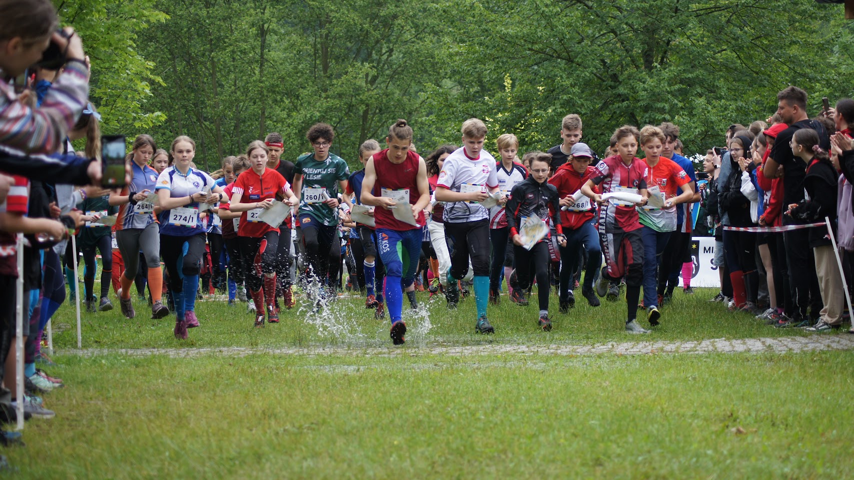 Fot. Ola Becmer. Zdjęcie przedstawia zawodników w Arboretum Leśnym na trasie biegu.